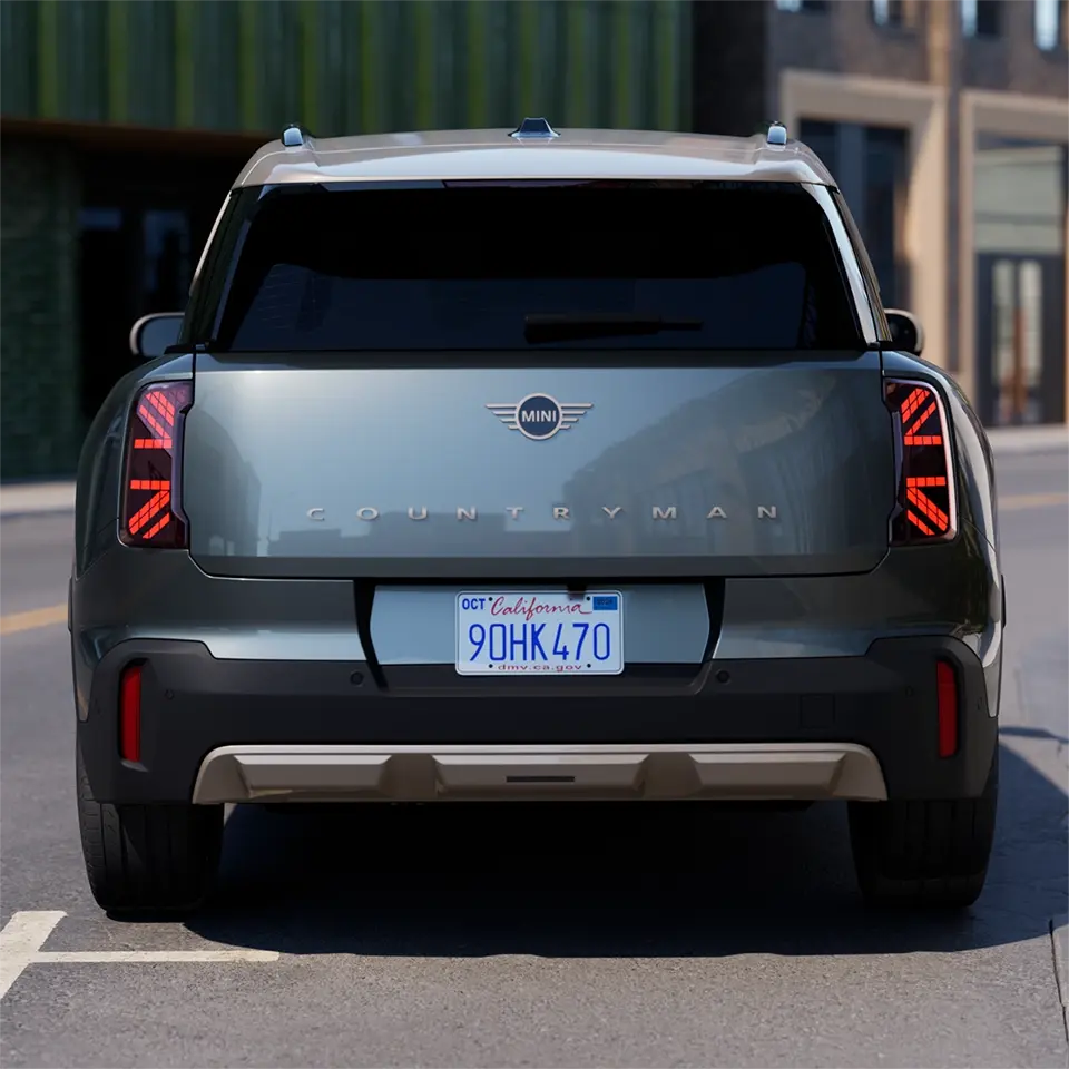 Vedere din spate a unui MINI Countryman de culoarea Smokey Green cu acoperiș Vibrant Silver