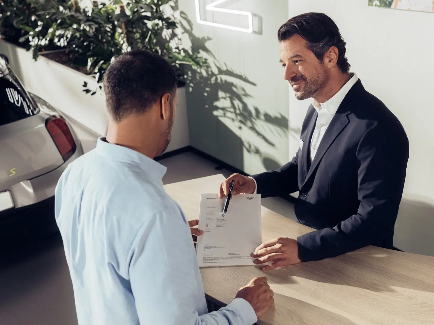 Asistent de service MINI Partner care sfătuieşte un client cu privire la opţiunile de asigurare MINI pentru anvelope.