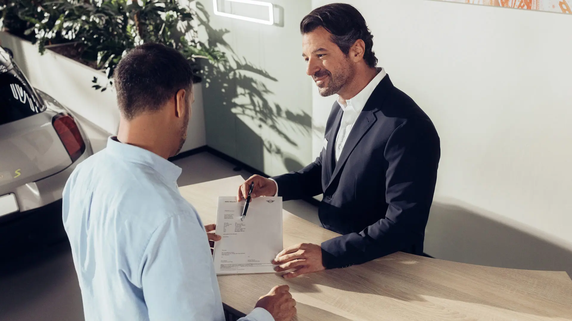 Asistent de service MINI Partner care sfătuieşte un client cu privire la opţiunile de asigurare MINI pentru anvelope.