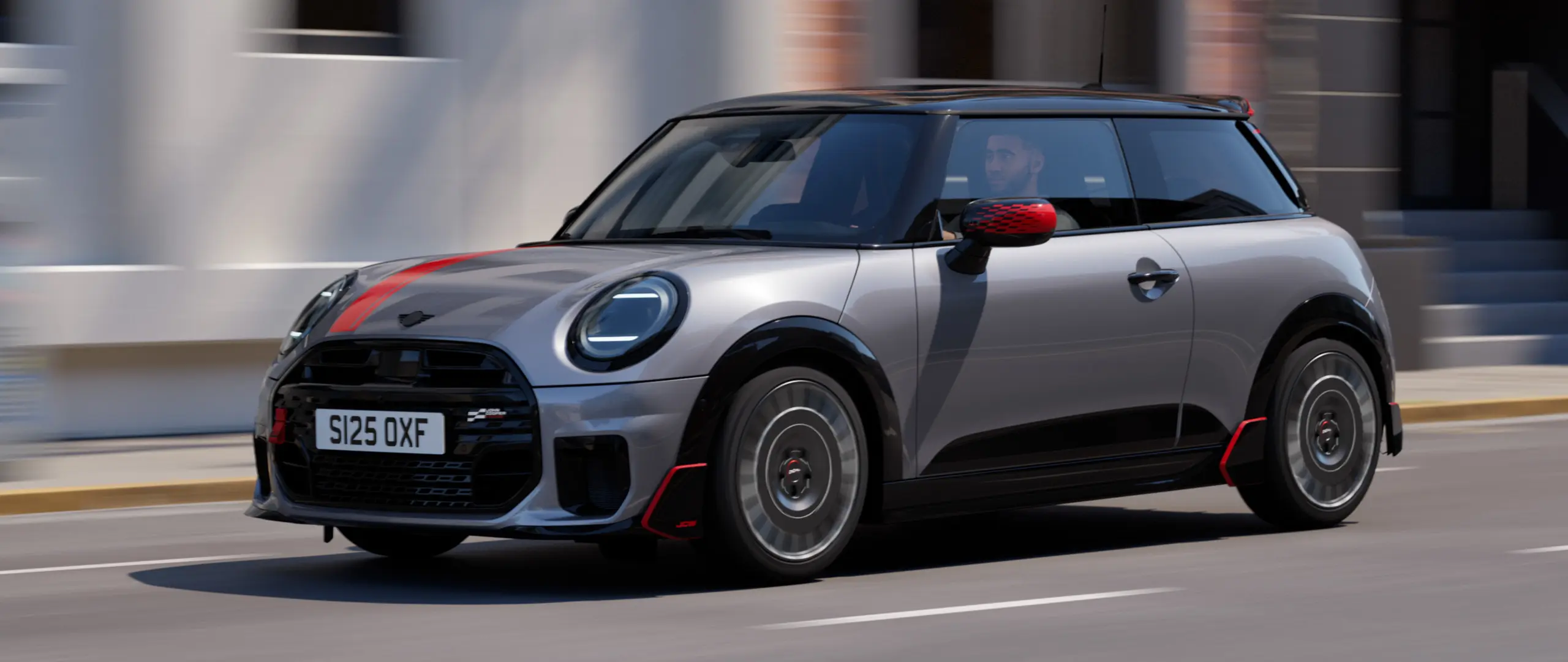 MINI Cooper cu 3 uşi de culoare Melting Silver, cu capace oglinzi John Cooper Works şi inscripţii pe capotă de culoare Chili Red, eleron şi aripioare negre.