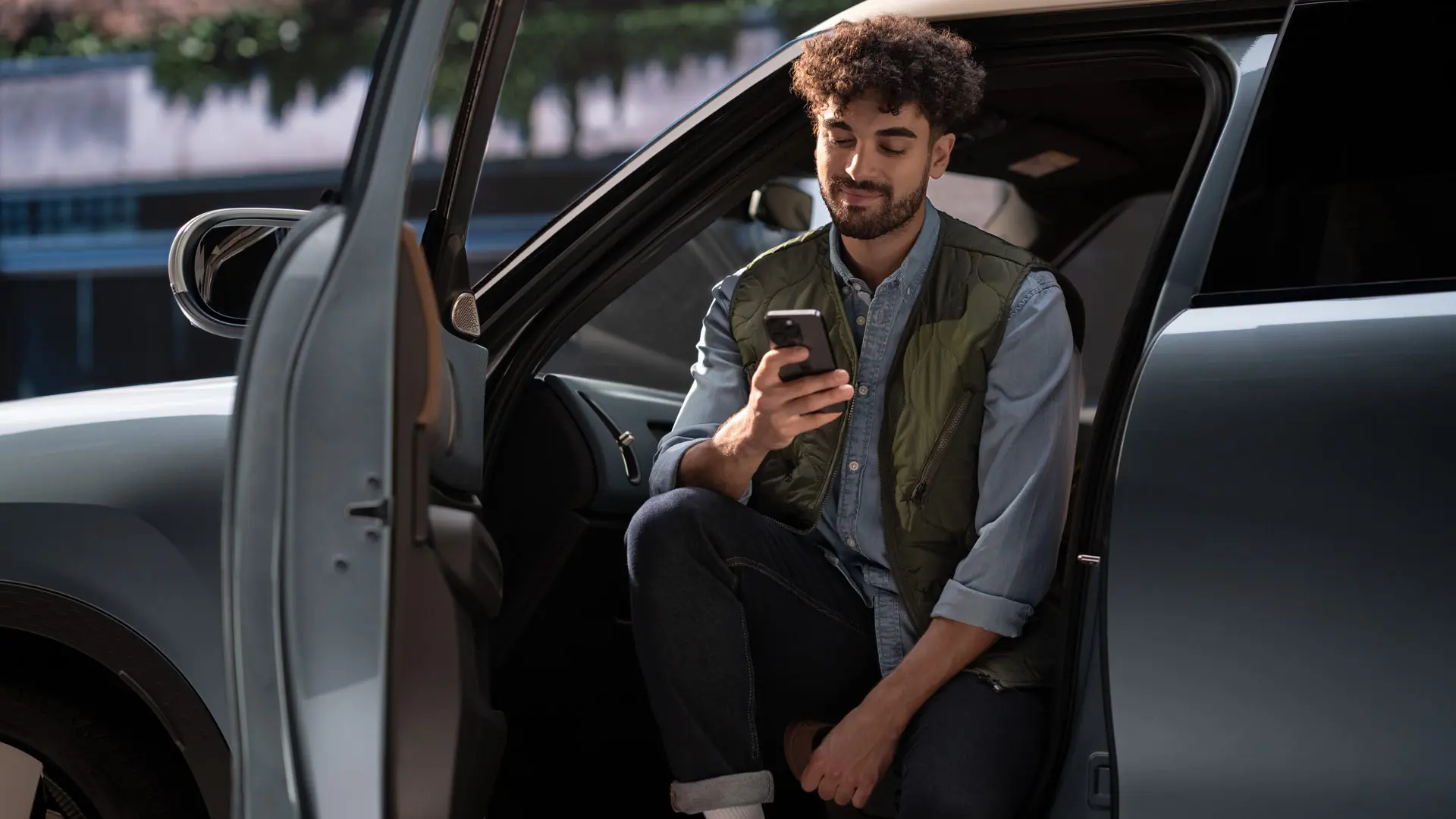 Un bărbat care face o programare în service folosind telefonul mobil.